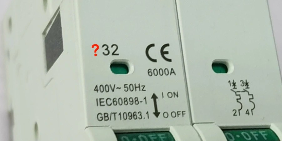 A close-up of a white circuit breaker showing printed specifications including CE mark, 6000A, 400V~50Hz, IEC60898-1, GB/T10963.1, and a red question mark next to the number 32.