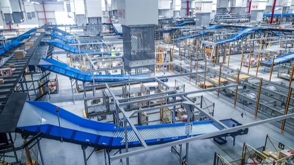 Industrial automated conveyor system in operation, featuring an extensive roller transfer network with metal frameworks for efficient heavy-duty production lines.