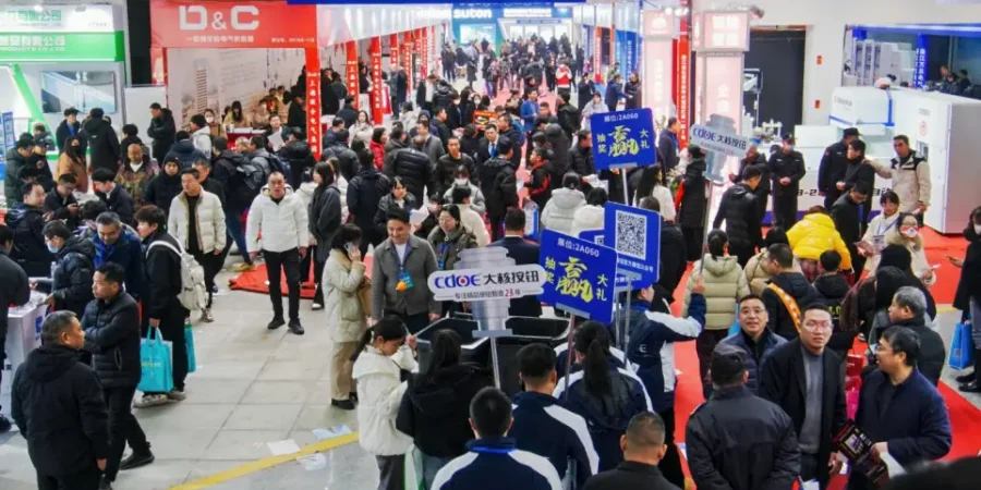 Crowded indoor expo with visitors walking between booths and blue promotional signs at the Liushi Electrical Culture Expo