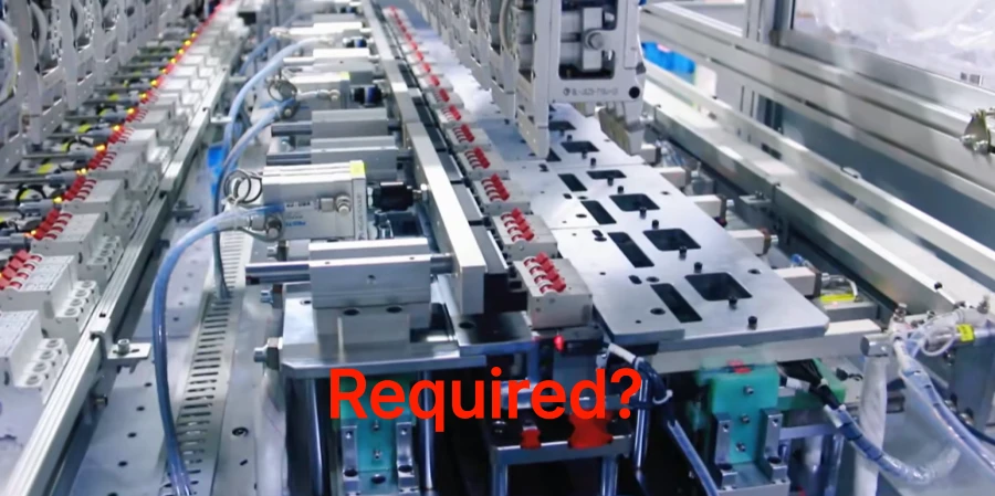 An automated MCB production line with metal parts, blue tubes, and red components, overlaid with the red text Required? in the center.