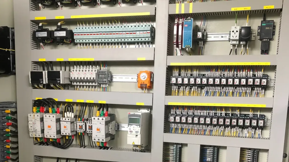 Industrial electrical control panel interior with neatly arranged miniature circuit breakers and terminal blocks on DIN rails
