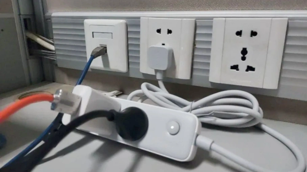 White power socket panels installed on an office wall with a multi-outlet design, connected to a white power strip below, providing convenient power expansion for office equipment.
