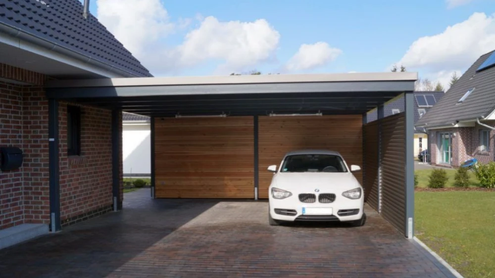 Outdoor standalone garage built in a villa courtyard, featuring a metal frame structure with ample space to fully accommodate a white car, showcasing a private residential parking shelter.