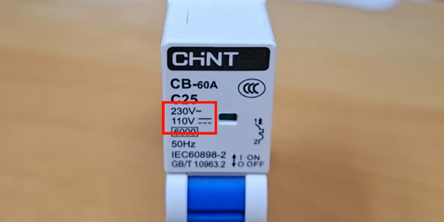 A close-up of a dual-use AC and DC MCB label with a red box around the text 230V~ and 110V DC.