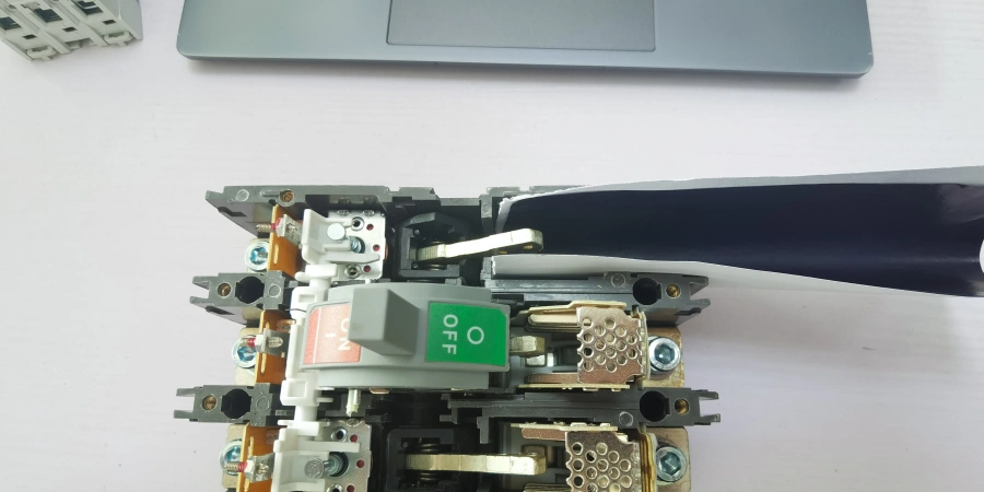 An MCCB with its cover removed, showing a piece of white paper and carbon paper placed between the stationary and moving contacts, with the switch in the OFF position.
